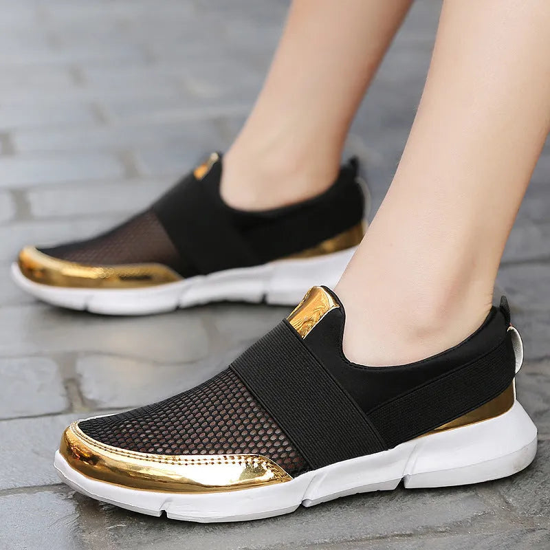 Low-cut blue, black, and grey women's sneakers with a mesh interior on a plain background.