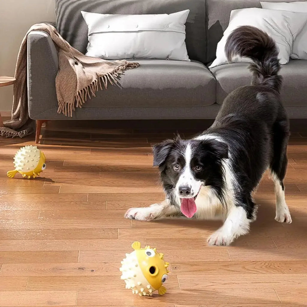 Yellow vinyl fish-shaped squeaky dog chew toy on a plain background