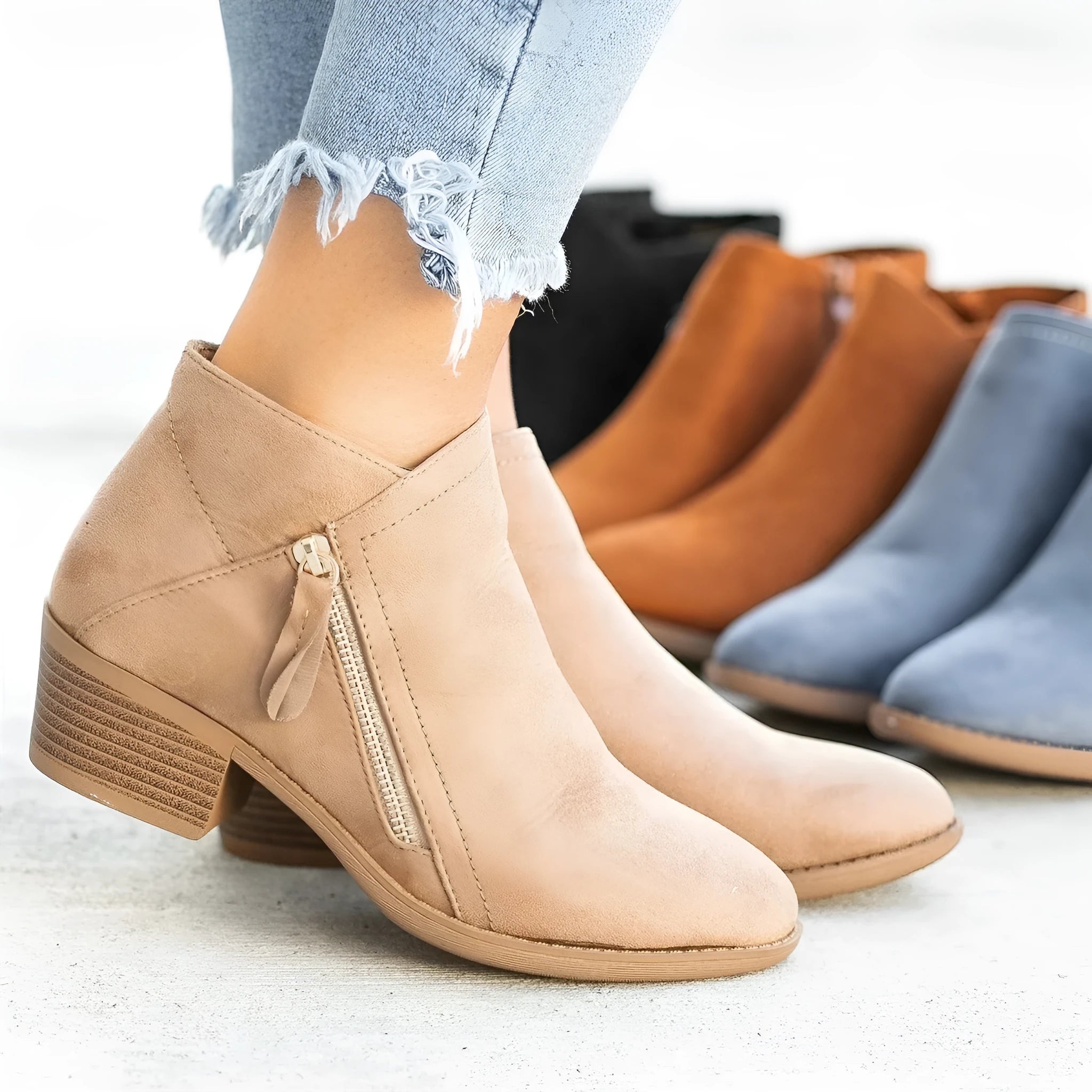 Women's suede ankle boots with a chunky heel and side zip, shown in beige, black, blue, and orange colour options.