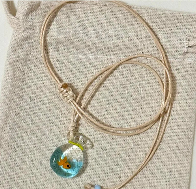 Women's pendant necklace with a coloured glaze skirt-shaped joker charm on a cotton and linen clavicle chain.