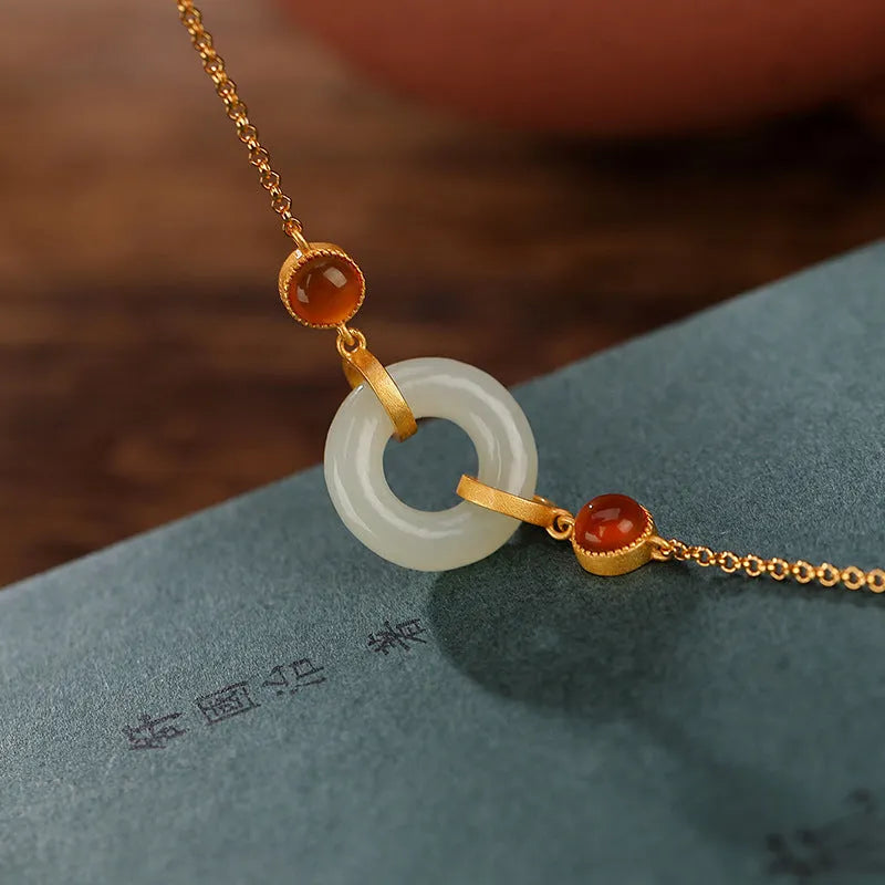 Women's sterling silver bracelet with gold-plated finish and natural Hetian jade peace buckle on adjustable chain