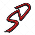 Red and silver SD design metal bumper sticker next to smaller red and black D design, showing scale.