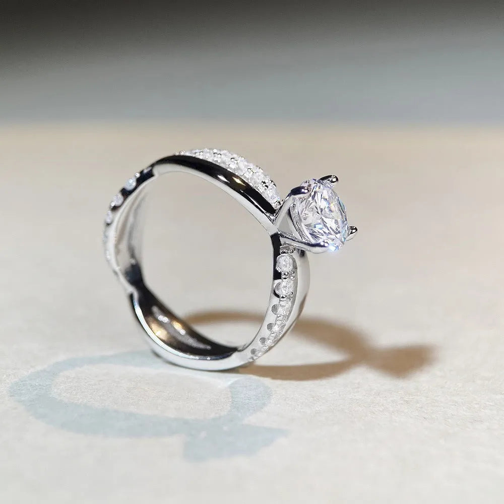 Silver geometric cross ring with a 1 karat moissanite stone in a twisted four-claw setting