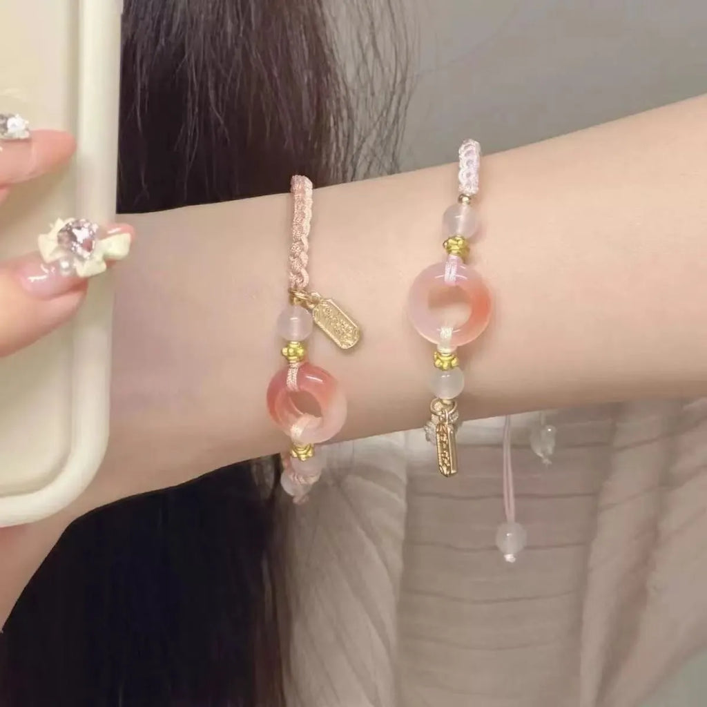 DIY woven unisex bracelet with peach blossom and peace buckle design in black, green, or pink.