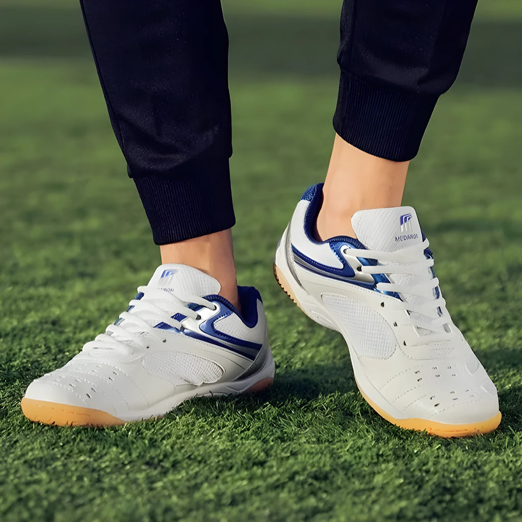 Mesh table tennis sneaker in white and red colour with lace-up front and rubber sole.