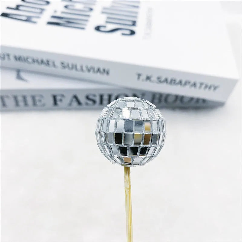 Glass mirrored disco ball cake decoration on a wooden stick, shown in different sizes.
