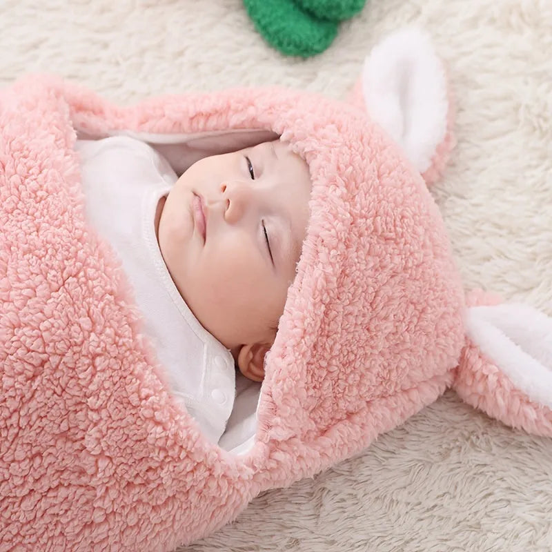 A baby wearing a soft grey fleece sleeping bag with hook-and-loop shoulder straps.