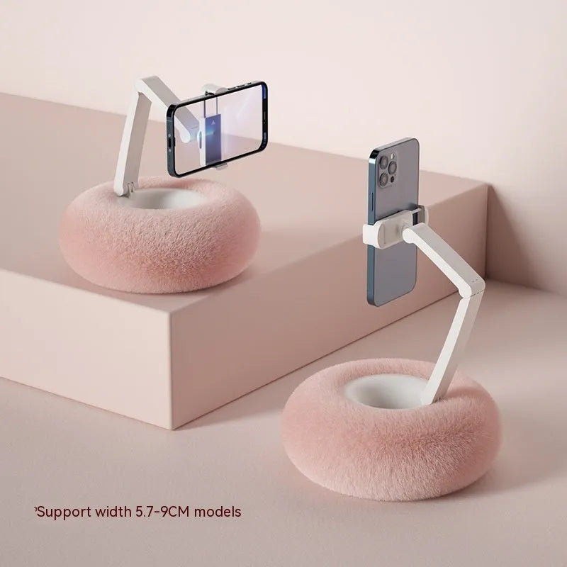 Adjustable rotating bracket holding a tablet, showing vertical extension rod and fabric-covered base.