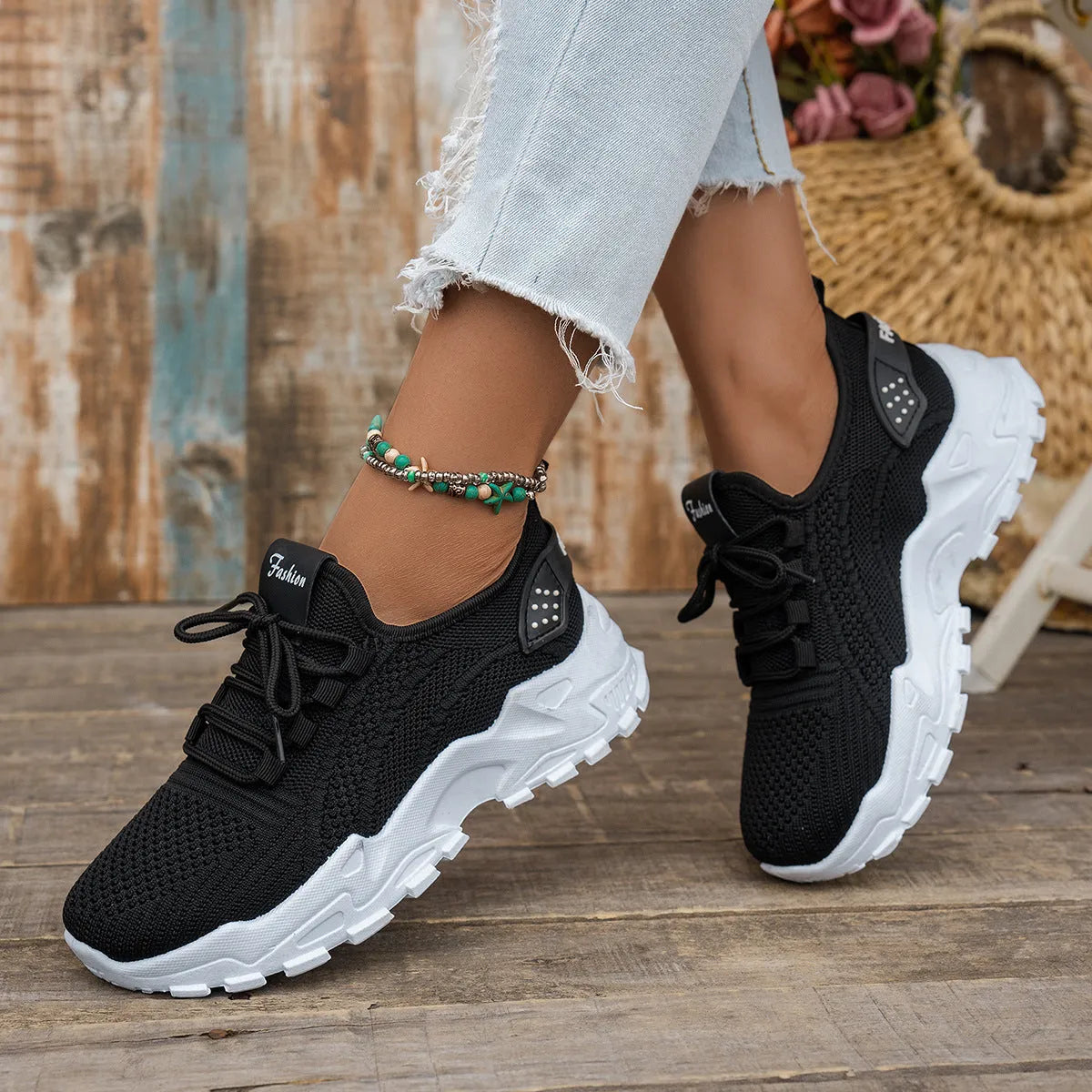 Women's white Flyknit mesh sports casual shoes with flat heel and lace-up front.