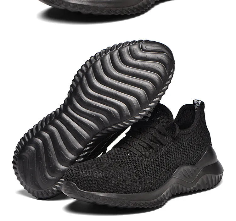Men's black steel toe cap safety shoes with a low-cut design on a work surface.