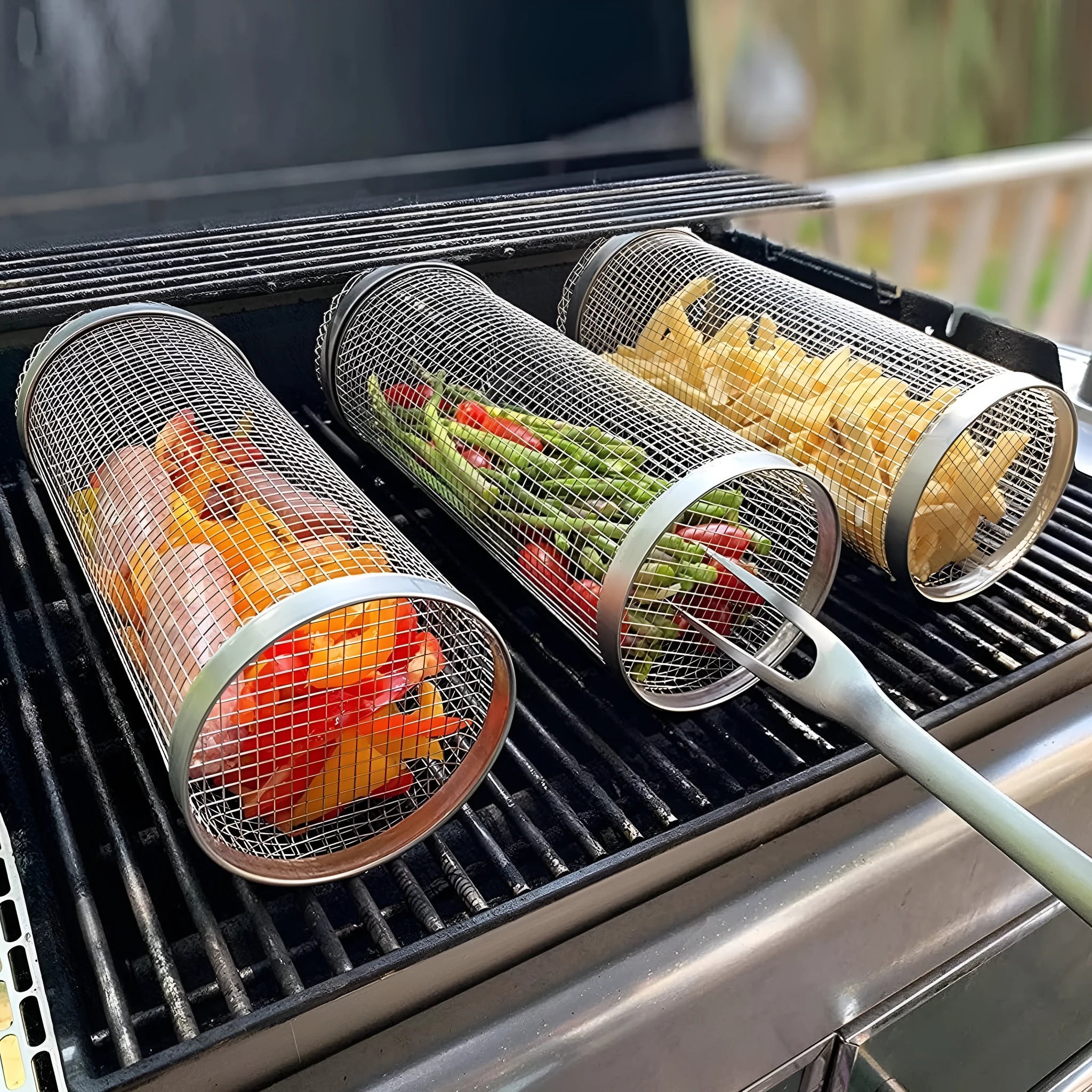 Round silver metal rolling barbecue basket with wire mesh and a hook, shown with vegetables inside on a grill.