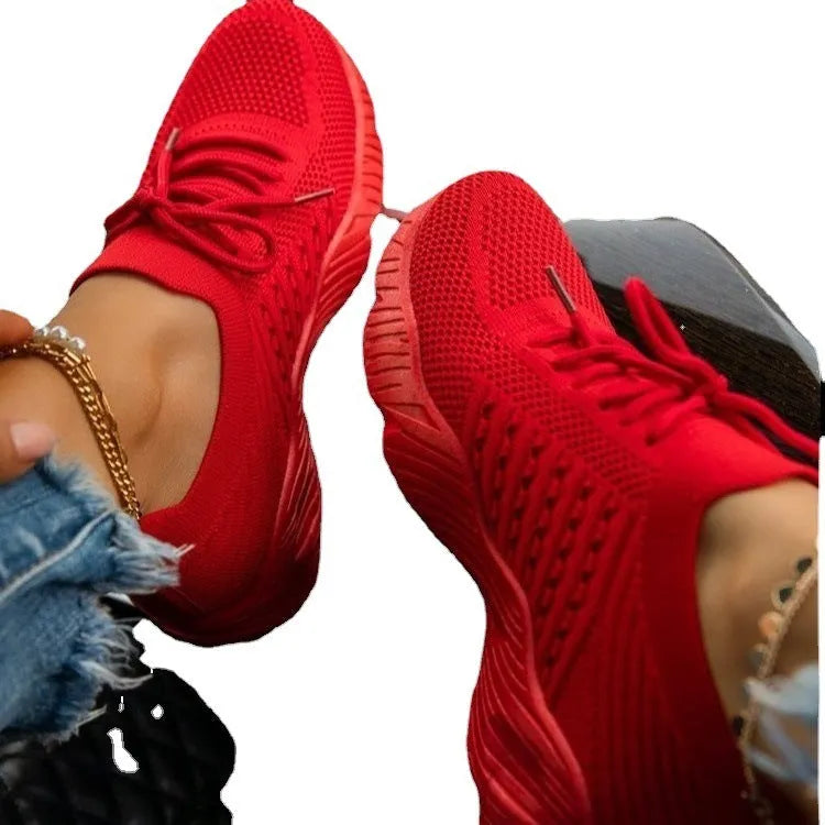 Women's white thick-sole dad-style sports sneakers on a neutral background.