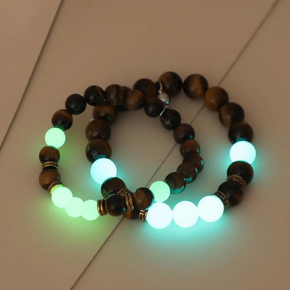 A pair of amber-coloured geometric resin bracelets with a luminous glow, shown together.