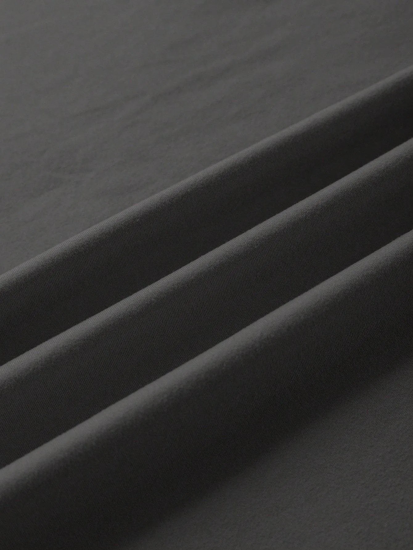 A loose-fitting unisex cotton T-shirt on a hanger, shown in one of its available colours.