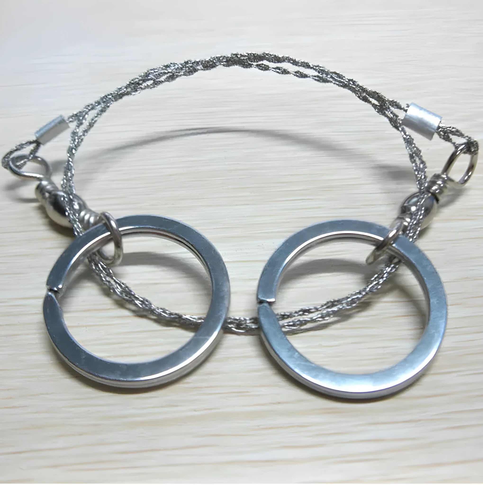 Stainless steel survival wire saw with pull rings, 55cm blade, total length 70cm.