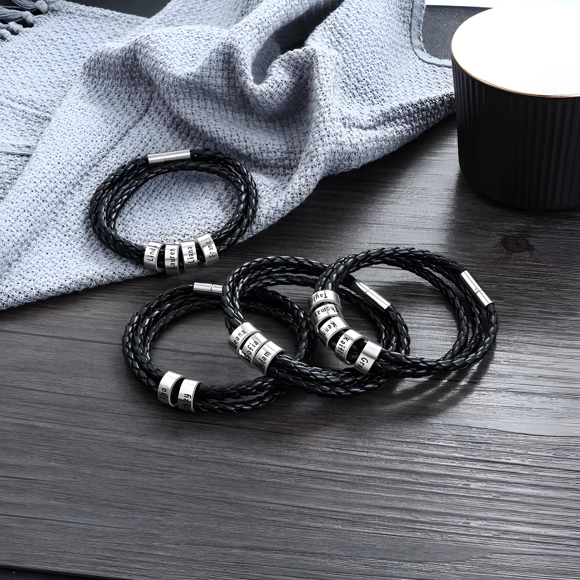 Personalised mens braided genuine leather bracelet in black with custom stainless steel name beads showing engraved names