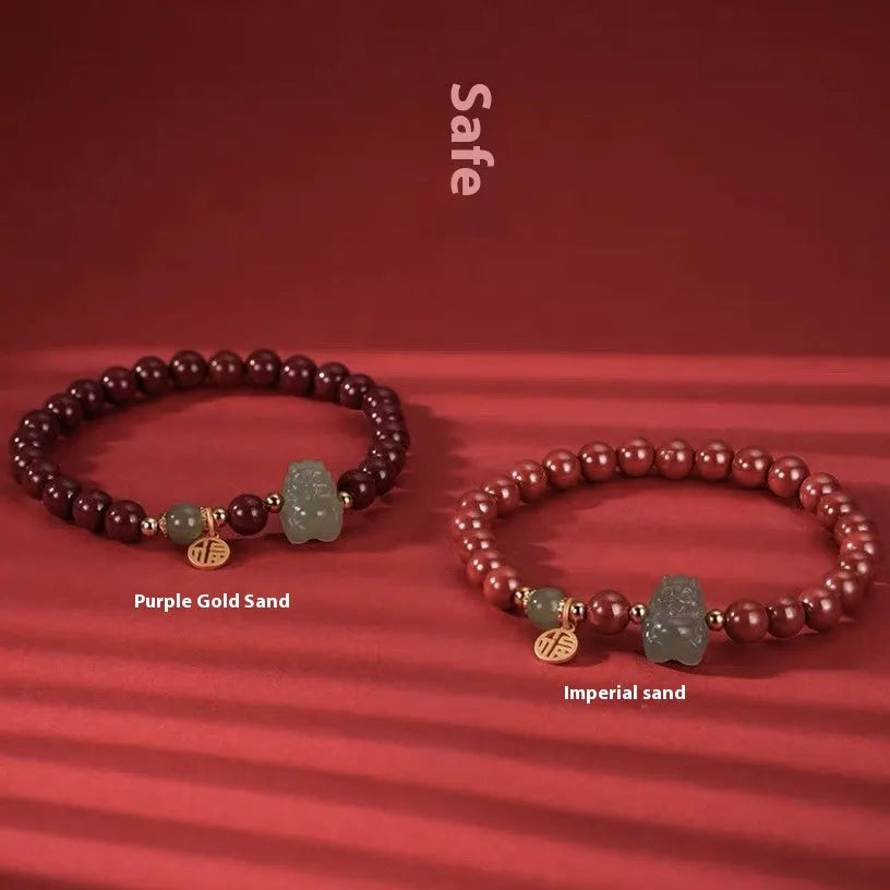 Natural Hetian Jade bracelet with cinnabar detail and zodiac charm on wrist.