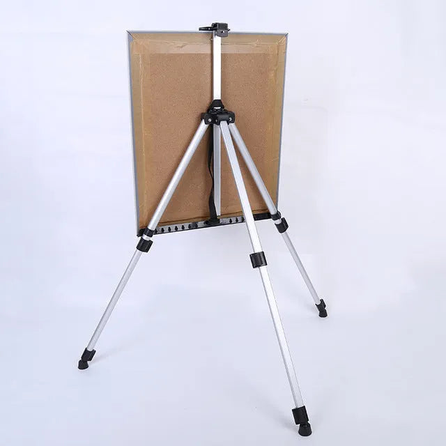 Silver aluminium alloy adjustable easel with metal tray, collapsed for table top use, next to a black nylon carrying bag