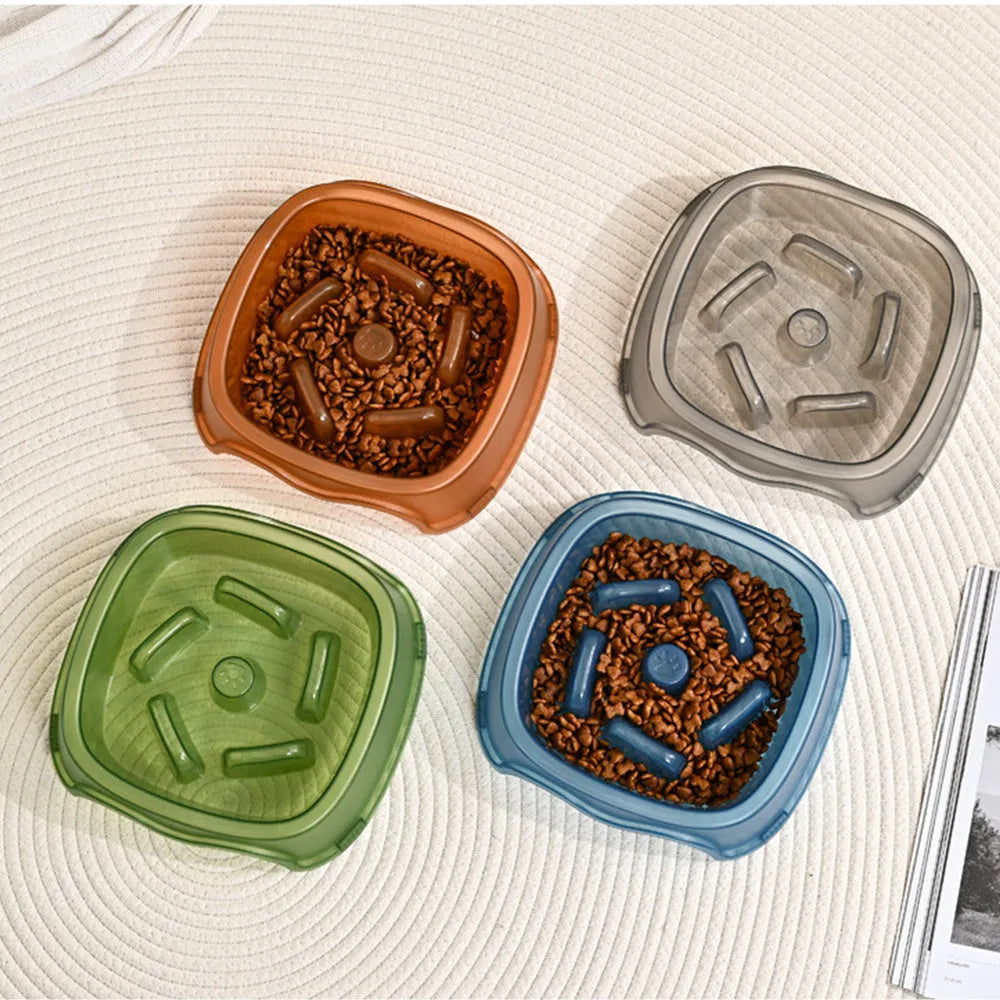 A blue plastic slow-feeder dog bowl on a wooden floor.
