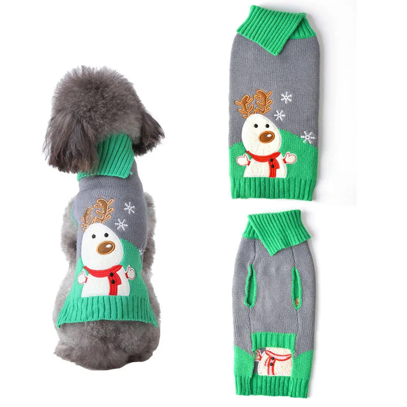Small dog wearing a black acrylic Christmas sweater with colourful pompoms, standing indoors