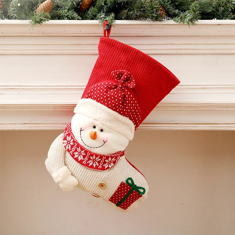 Large red and white knitted Christmas stocking with Santa Claus design hanging from fireplace