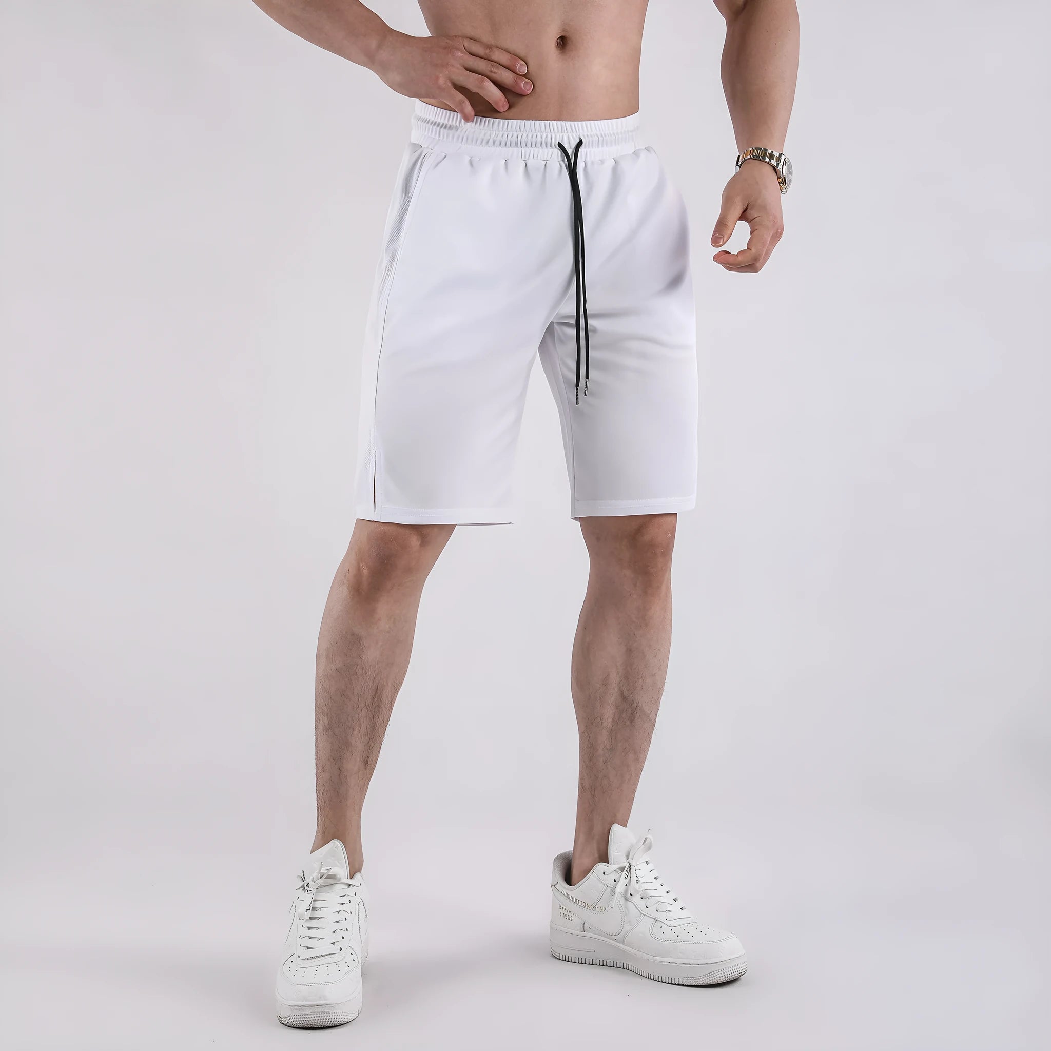 Man wearing black loose-fit mesh capri shorts with an elastic waist for sports.