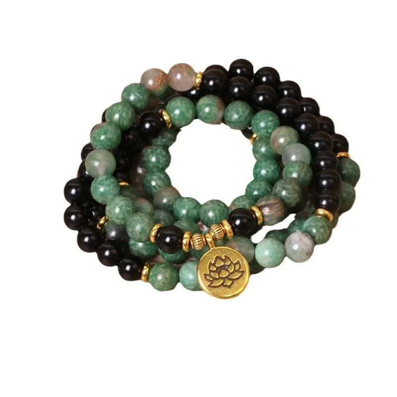 Green and black alloy bead elastic bracelet on a wrist.