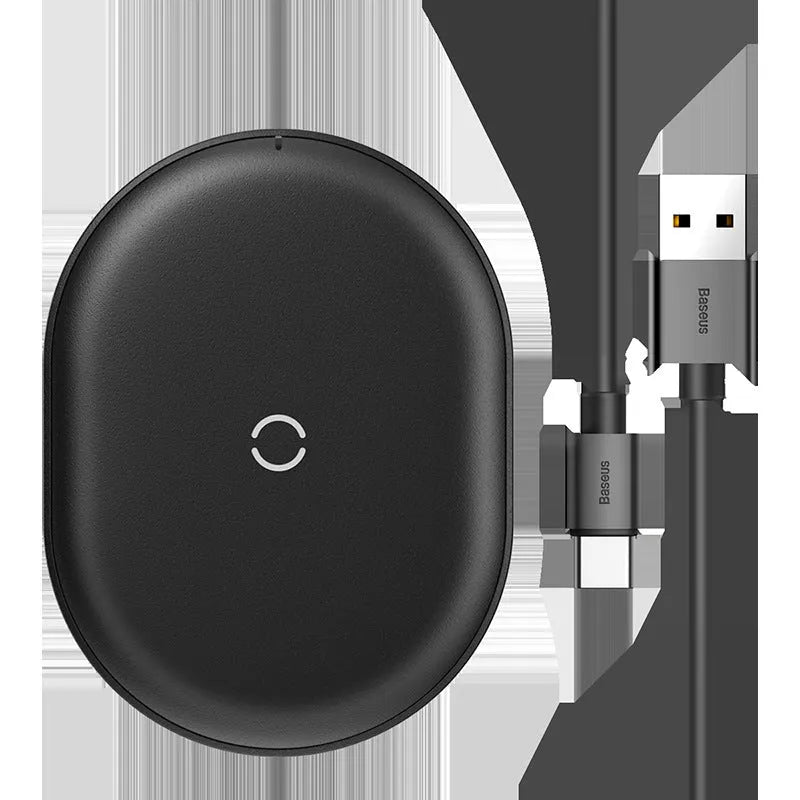 Baseus Rough 15W wireless charging pad in black on a desk next to a mobile phone.