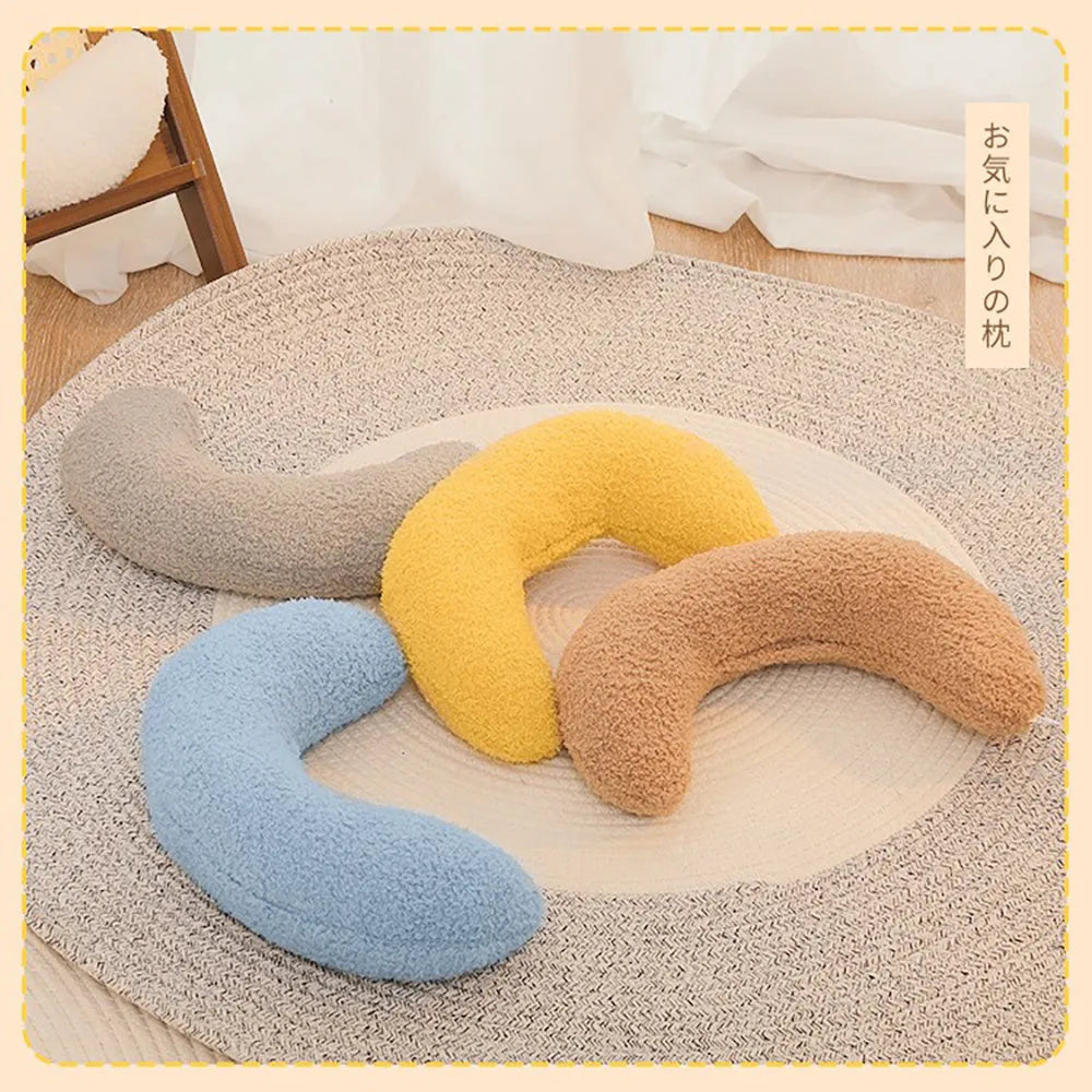 U-shaped blue cat pillow with adjustable neck collar on a sofa