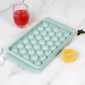 Blue silicone ice cube tray with lid showing 33 round cavities for large ice.