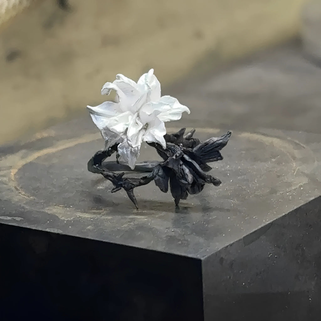 Bipolar Disorder French Simplicity copper ring in white and black with lily motif on neutral background