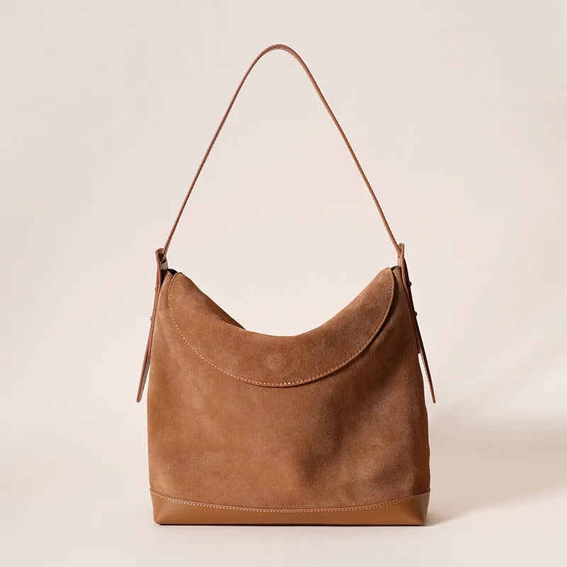 Light brown genuine leather women's retro shoulder bag with clamshell opening on a table.