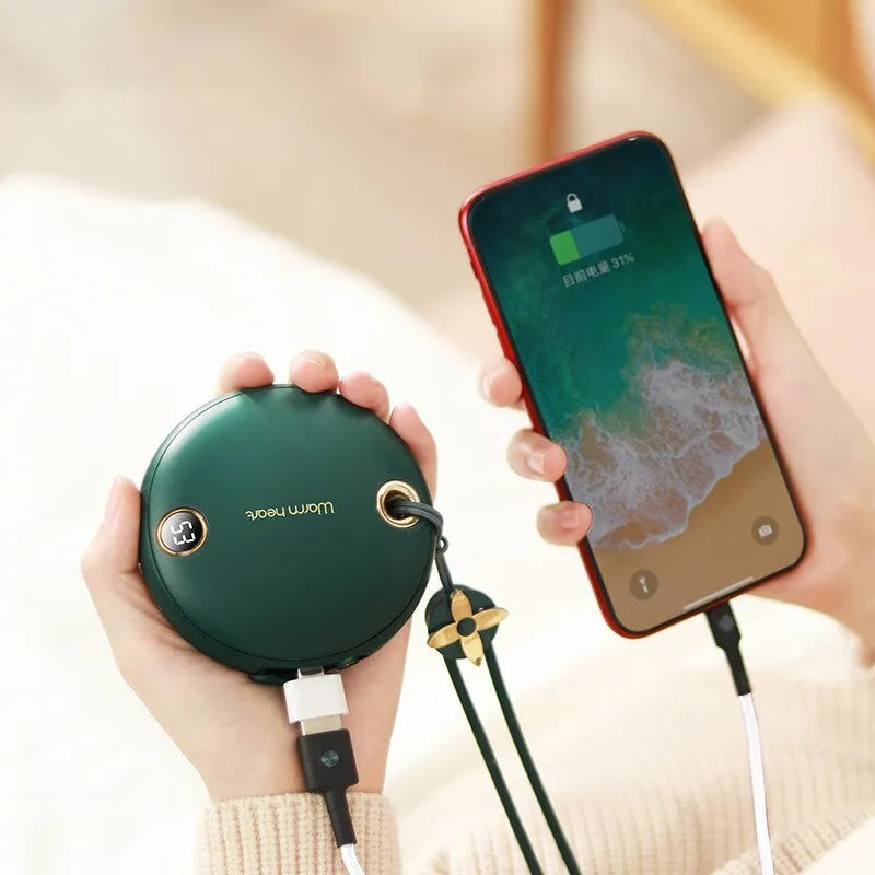 Green, pink, or white square 5000mAh hand warmer power bank with digital display next to charging cable.
