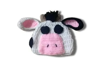 White hand-knitted baby cow suit set with matching hat and trousers for newborns.