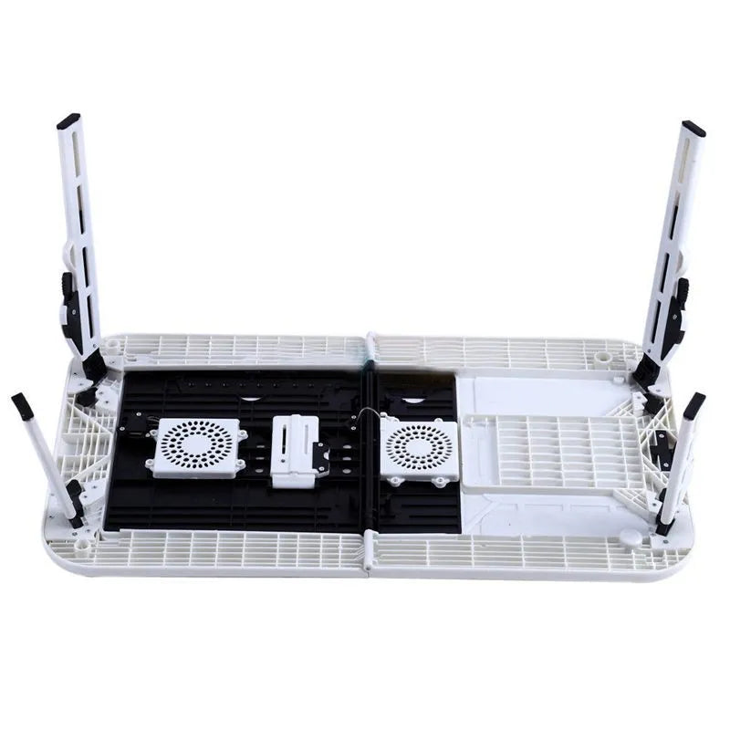 White folding computer desk bed with adjustable legs and tilting baseplate, open on a bed showing dual heat vents
