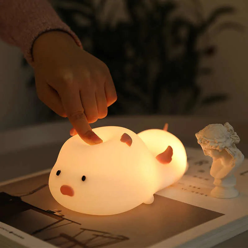 Blue silicone pig-shaped night light with USB charging port