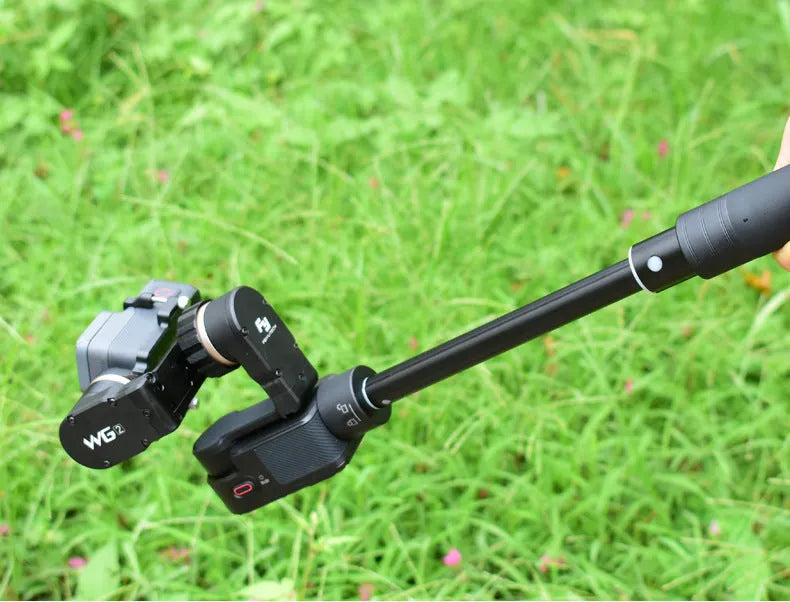 Black retractable aluminium selfie stick extended to full length with a smartphone attached in the clamp.