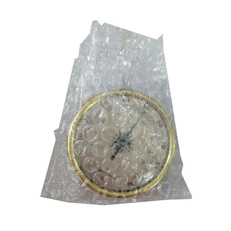 Analog thermometer and hygrometer with aluminium dial and outer ring on a white background.