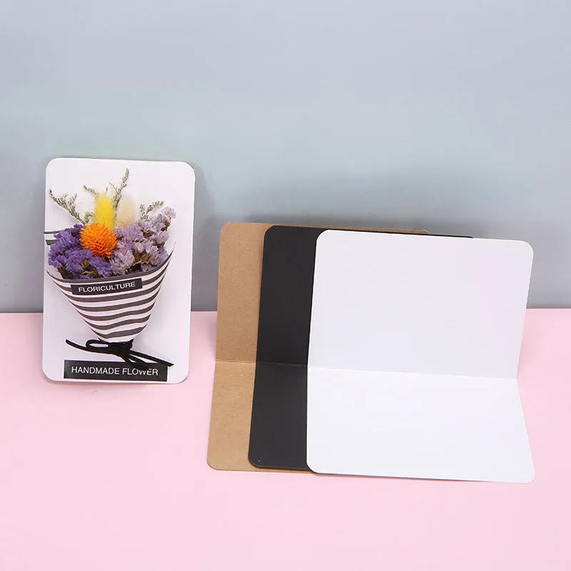 Pack of 100 blank folded kraft paper greeting cards in 10x15cm size, showing black, cowhide brown, and white colour options