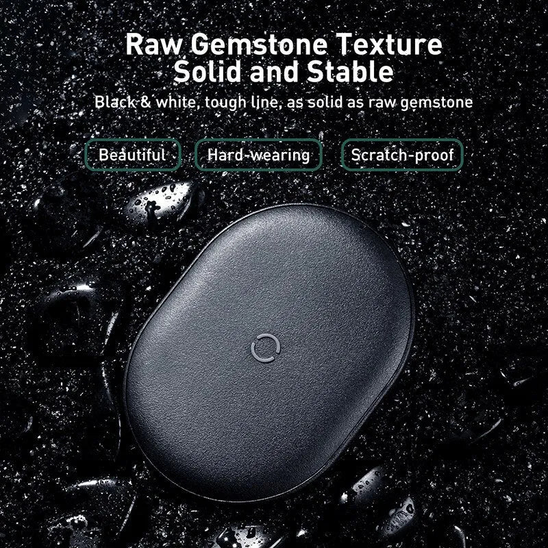 Baseus Rough 15W wireless charging pad in black on a desk next to a mobile phone.