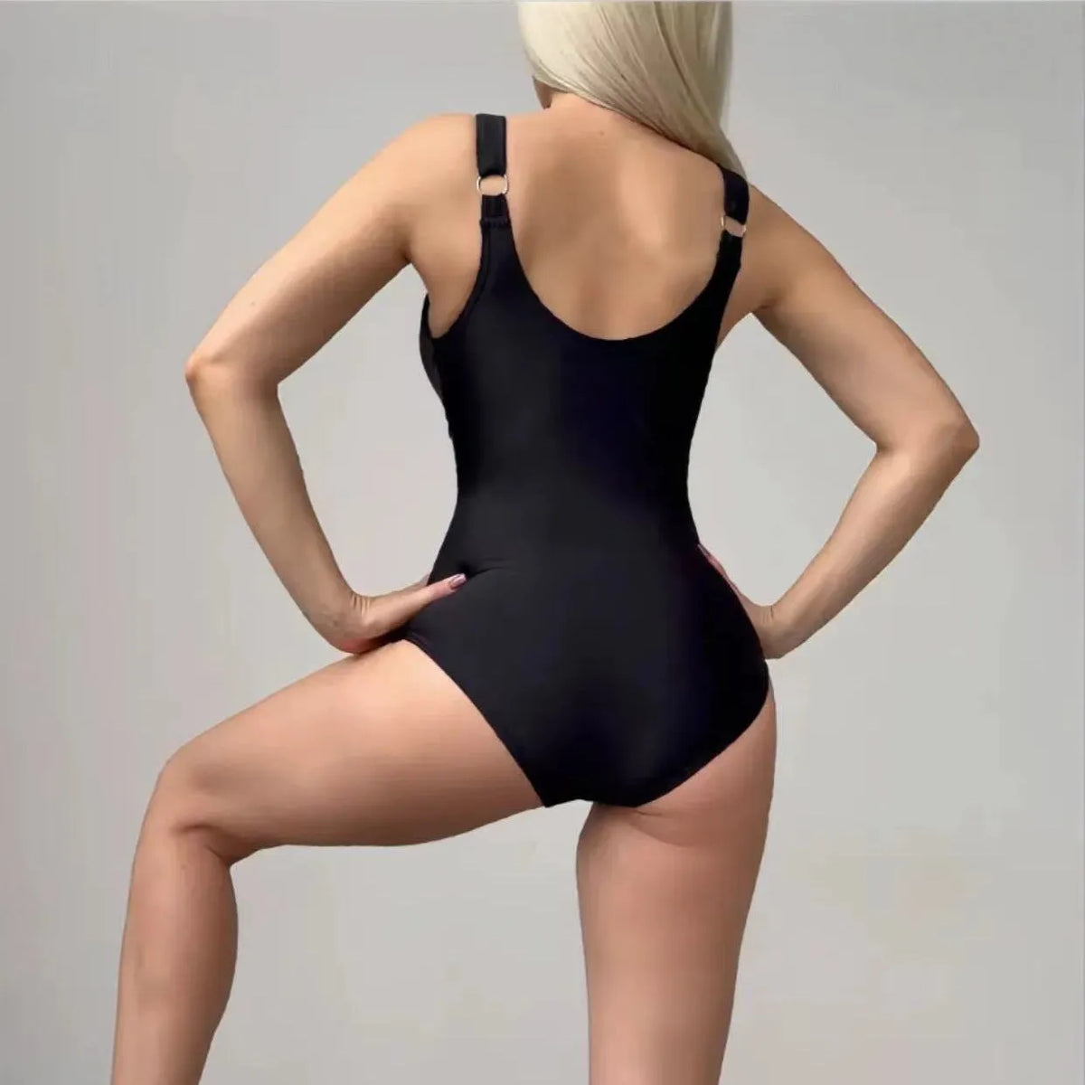 Women's black nylon lace-up tight one-piece swimsuit on plain background