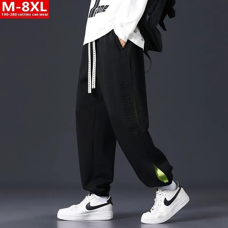 Men's grey green loose-fit cargo trousers with visible stitching detail and a banded ankle opening.