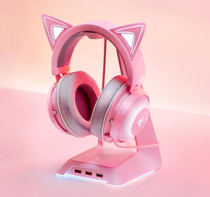 Pink glowing cat earphones with wired USB connection and head-mounted design on a desk