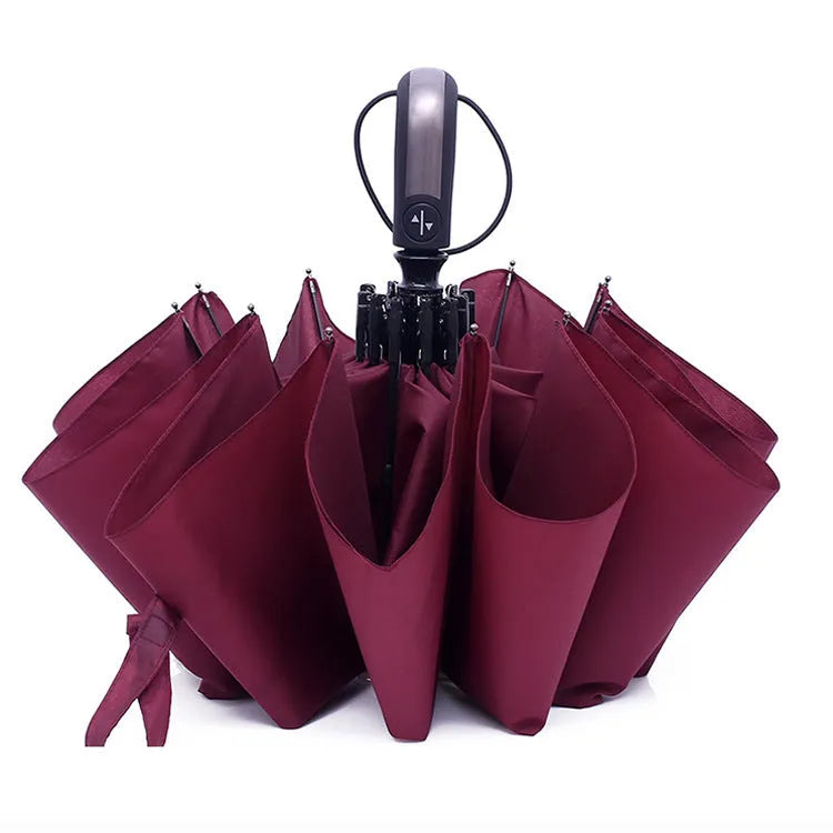Black triple folding automatic umbrella with a palace-style shape and rubber handle.