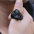 Men's obsidian pixiu thumb ring showing gold sheen and detailed carving on a hand.