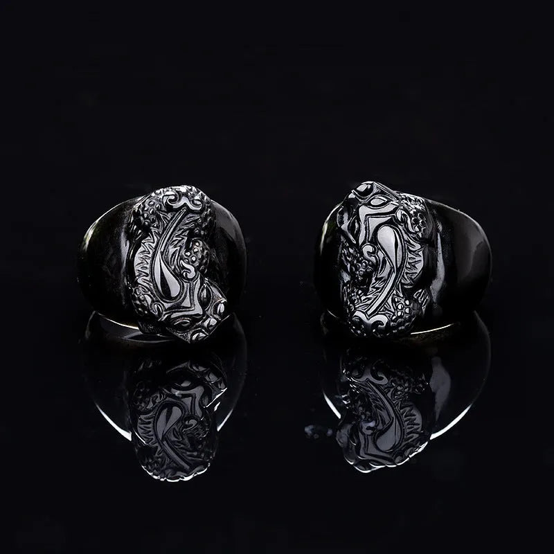 Men's obsidian pixiu thumb ring showing gold sheen and detailed carving on a hand.