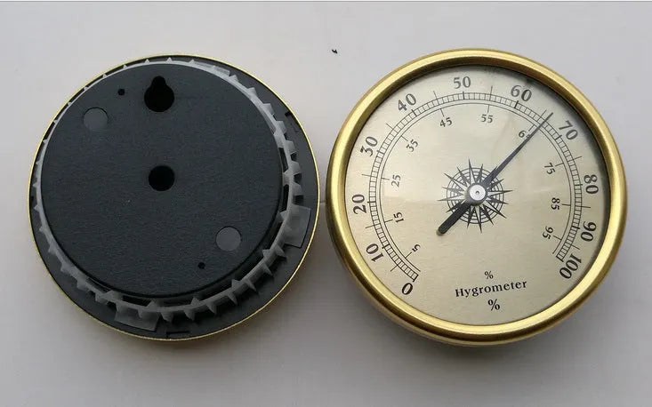 Analog thermometer and hygrometer with aluminium dial and outer ring on a white background.