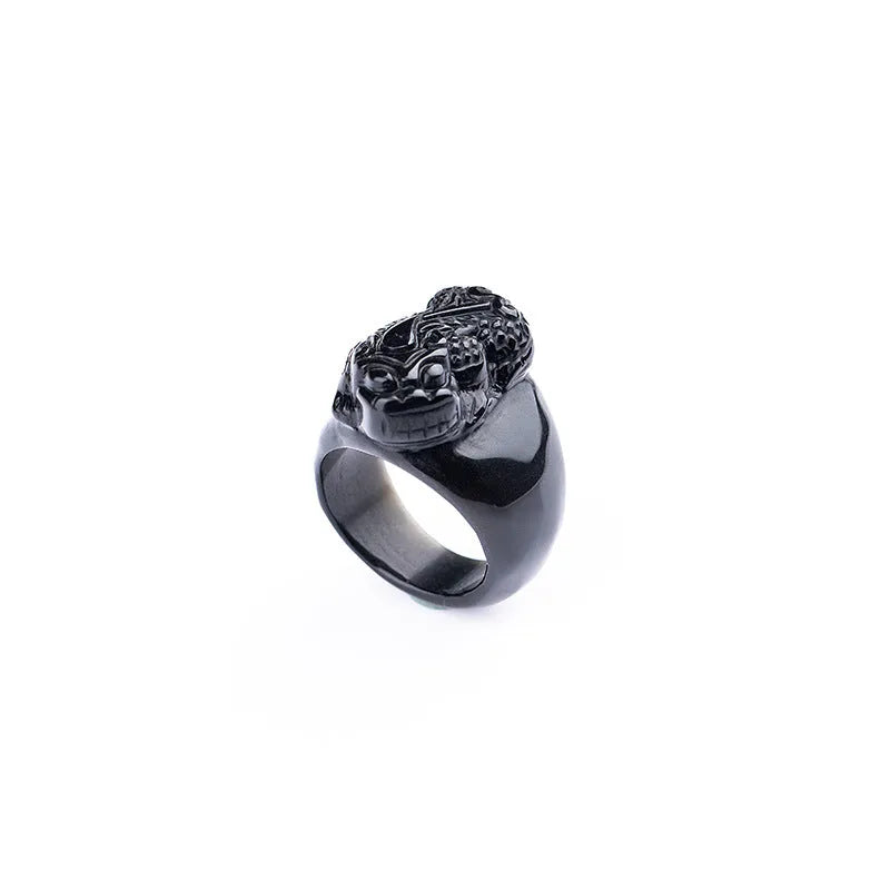 Men's obsidian pixiu thumb ring showing gold sheen and detailed carving on a hand.