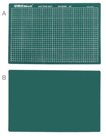 Green A3 self-healing cutting mat with centimetre grid lines, shown on a desk.