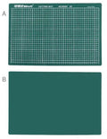 Green A3 self-healing cutting mat with centimetre grid lines, shown on a desk.